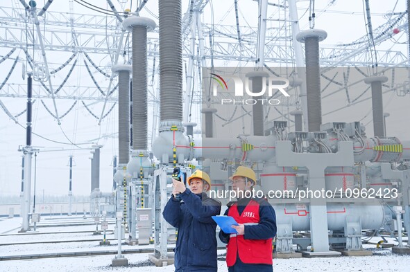 Power workers are carrying out a post-snow inspection of power supply equipment at a 500-kilovolt substation in Meizhuang village, Chuzhou c...