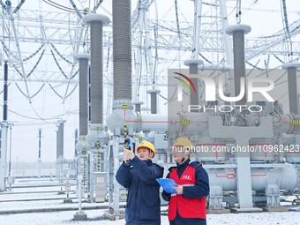 Power workers are carrying out a post-snow inspection of power supply equipment at a 500-kilovolt substation in Meizhuang village, Chuzhou c...