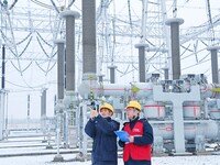 Power workers are carrying out a post-snow inspection of power supply equipment at a 500-kilovolt substation in Meizhuang village, Chuzhou c...