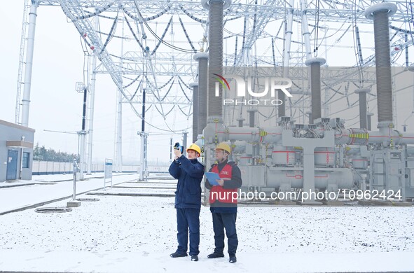 Power workers are carrying out a post-snow inspection of power supply equipment at a 500-kilovolt substation in Meizhuang village, Chuzhou c...