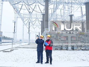 Power workers are carrying out a post-snow inspection of power supply equipment at a 500-kilovolt substation in Meizhuang village, Chuzhou c...