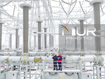 Power workers are carrying out a post-snow inspection of power supply equipment at a 500-kilovolt substation in Meizhuang village, Chuzhou c...