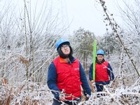 Electric workers are patrolling power supply lines after snow in Meizhou village, Chuzhou, China, on February 4, 2024. (