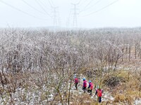 Electric workers are patrolling power supply lines after snow in Meizhou village, Chuzhou, China, on February 4, 2024. (