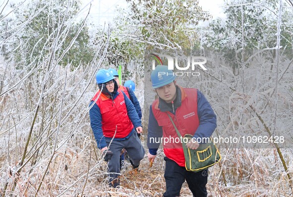 Electric workers are patrolling power supply lines after snow in Meizhou village, Chuzhou, China, on February 4, 2024. 