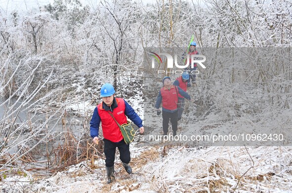 Electric workers are patrolling power supply lines after snow in Meizhou village, Chuzhou, China, on February 4, 2024. 