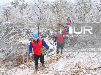 Electric workers are patrolling power supply lines after snow in Meizhou village, Chuzhou, China, on February 4, 2024. (