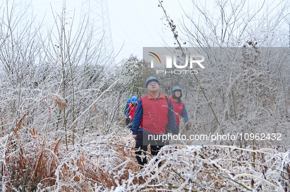 Electric workers are patrolling power supply lines after snow in Meizhou village, Chuzhou, China, on February 4, 2024. 