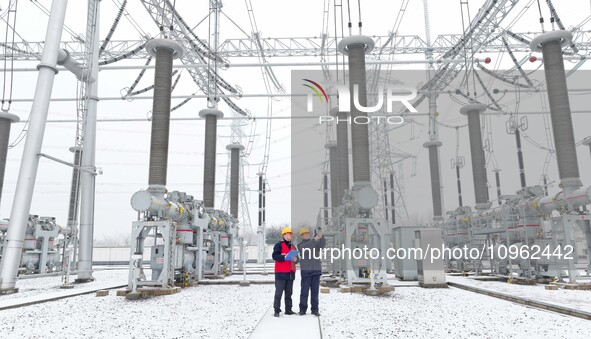 Power workers are carrying out a post-snow inspection of power supply equipment at a 500-kilovolt substation in Meizhuang village, Chuzhou c...