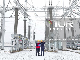 Power workers are carrying out a post-snow inspection of power supply equipment at a 500-kilovolt substation in Meizhuang village, Chuzhou c...