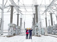 Power workers are carrying out a post-snow inspection of power supply equipment at a 500-kilovolt substation in Meizhuang village, Chuzhou c...