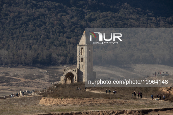 Hundreds of people are visiting the old town of Sant Roma de Sau, where normally the water of the Sau reservoir would almost completely cove...