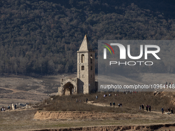 Hundreds of people are visiting the old town of Sant Roma de Sau, where normally the water of the Sau reservoir would almost completely cove...