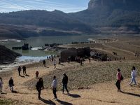 Hundreds of people are visiting the old town of Sant Roma de Sau, where normally the water of the Sau reservoir would almost completely cove...