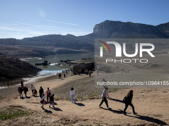 Hundreds of people are visiting the old town of Sant Roma de Sau, where normally the water of the Sau reservoir would almost completely cove...