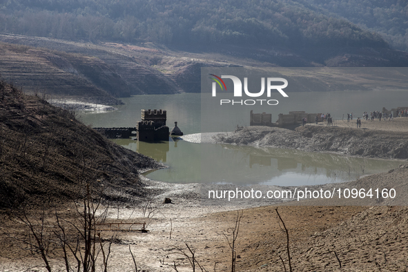 Hundreds of people are visiting the old town of Sant Roma de Sau, where normally the water of the Sau reservoir would almost completely cove...