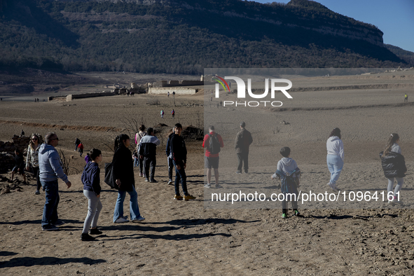 Hundreds of people are visiting the old town of Sant Roma de Sau, where normally the water of the Sau reservoir would almost completely cove...