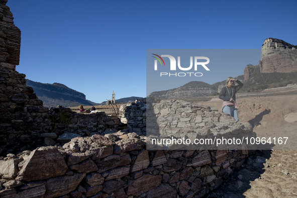 Hundreds of people are visiting the old town of Sant Roma de Sau, where normally the water of the Sau reservoir would almost completely cove...