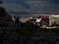 Hundreds of people are visiting the old town of Sant Roma de Sau, where normally the water of the Sau reservoir would almost completely cove...