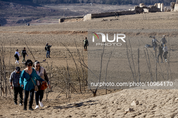 Hundreds of people are visiting the old town of Sant Roma de Sau, where normally the water of the Sau reservoir would almost completely cove...