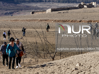 Hundreds of people are visiting the old town of Sant Roma de Sau, where normally the water of the Sau reservoir would almost completely cove...