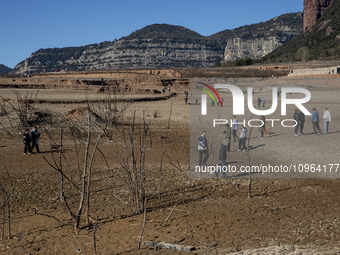 Hundreds of people are visiting the old town of Sant Roma de Sau, where normally the water of the Sau reservoir would almost completely cove...