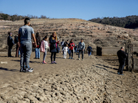 Hundreds of people are visiting the old town of Sant Roma de Sau, where normally the water of the Sau reservoir would almost completely cove...