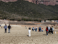 Hundreds of people are visiting the old town of Sant Roma de Sau, where normally the water of the Sau reservoir would almost completely cove...