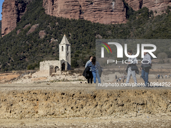 Hundreds of people are visiting the old town of Sant Roma de Sau, where normally the water of the Sau reservoir would almost completely cove...