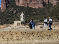 Hundreds of people are visiting the old town of Sant Roma de Sau, where normally the water of the Sau reservoir would almost completely cove...