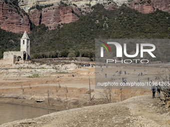 Hundreds of people are visiting the old town of Sant Roma de Sau, where normally the water of the Sau reservoir would almost completely cove...