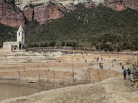 Hundreds of people are visiting the old town of Sant Roma de Sau, where normally the water of the Sau reservoir would almost completely cove...