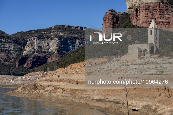 Hundreds of people are visiting the old town of Sant Roma de Sau, where normally the water of the Sau reservoir would almost completely cove...