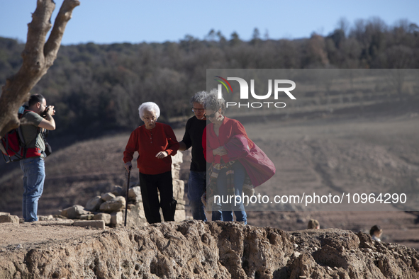 Hundreds of people are visiting the old town of Sant Roma de Sau, where normally the water of the Sau reservoir would almost completely cove...