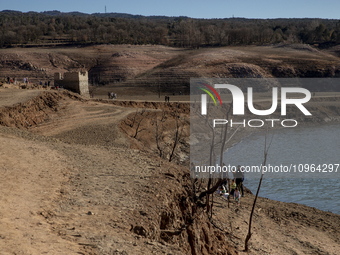 Hundreds of people are visiting the old town of Sant Roma de Sau, where normally the water of the Sau reservoir would almost completely cove...