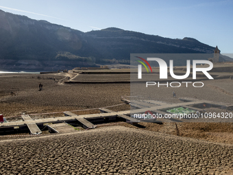 Hundreds of people are visiting the old town of Sant Roma de Sau, where normally the water of the Sau reservoir would almost completely cove...