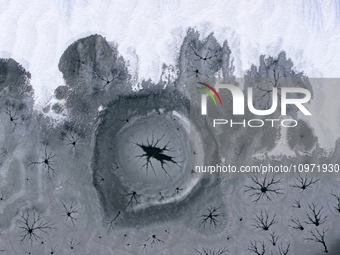 Ice trees and flowers are forming a patterned landscape on a frozen lake in the West Coast New Area of Qingdao, Shandong Province, China, on...