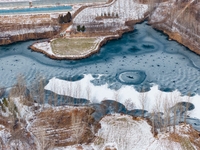 Ice trees and flowers are forming a patterned landscape on a frozen lake in the West Coast New Area of Qingdao, Shandong Province, China, on...