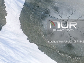 Ice trees and flowers are forming a patterned landscape on a frozen lake in the West Coast New Area of Qingdao, Shandong Province, China, on...