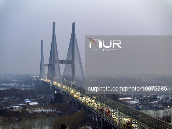 A large number of vehicles are traveling slowly on the section of the Huaian Bridge on the Changzhou-Shenzhen Expressway in Huai'an, China,...