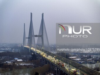 A large number of vehicles are traveling slowly on the section of the Huaian Bridge on the Changzhou-Shenzhen Expressway in Huai'an, China,...