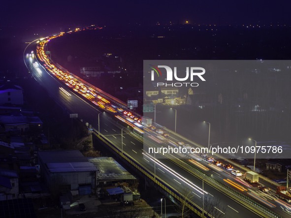 A large number of vehicles are traveling slowly on the section of the Huaian Bridge on the Changzhou-Shenzhen Expressway in Huai'an, China,...