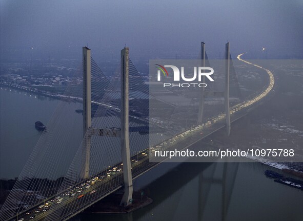 A large number of vehicles are traveling slowly on the section of the Huaian Bridge on the Changzhou-Shenzhen Expressway in Huai'an, China,...