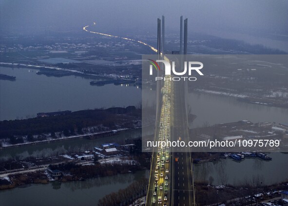 A large number of vehicles are traveling slowly on the section of the Huaian Bridge on the Changzhou-Shenzhen Expressway in Huai'an, China,...