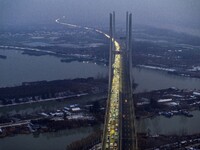 A large number of vehicles are traveling slowly on the section of the Huaian Bridge on the Changzhou-Shenzhen Expressway in Huai'an, China,...