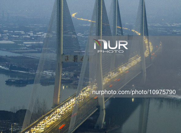 A large number of vehicles are traveling slowly on the section of the Huaian Bridge on the Changzhou-Shenzhen Expressway in Huai'an, China,...