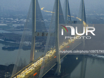 A large number of vehicles are traveling slowly on the section of the Huaian Bridge on the Changzhou-Shenzhen Expressway in Huai'an, China,...