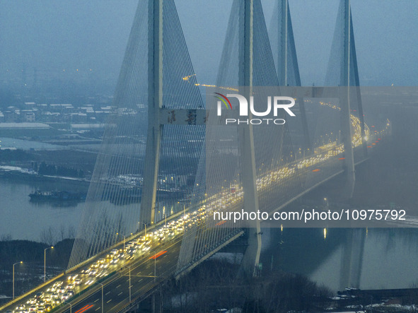 A large number of vehicles are traveling slowly on the section of the Huaian Bridge on the Changzhou-Shenzhen Expressway in Huai'an, China,...