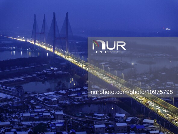 A large number of vehicles are traveling slowly on the section of the Huaian Bridge on the Changzhou-Shenzhen Expressway in Huai'an, China,...