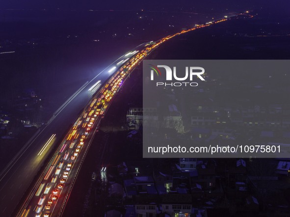 A large number of vehicles are traveling slowly on the section of the Huaian Bridge on the Changzhou-Shenzhen Expressway in Huai'an, China,...